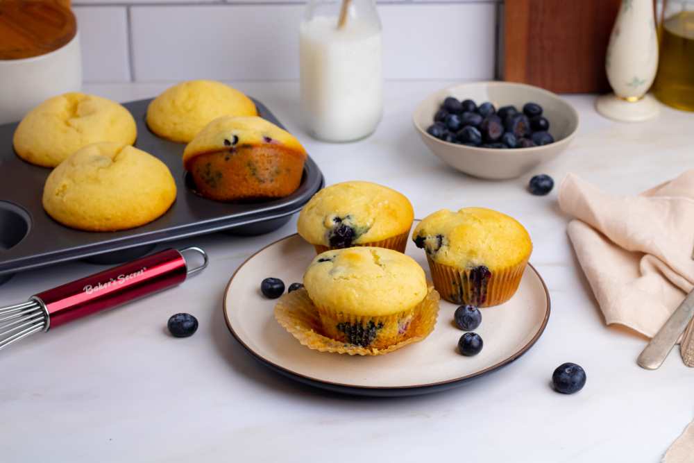 Blueberry muffins on a plate with fresh blueberries