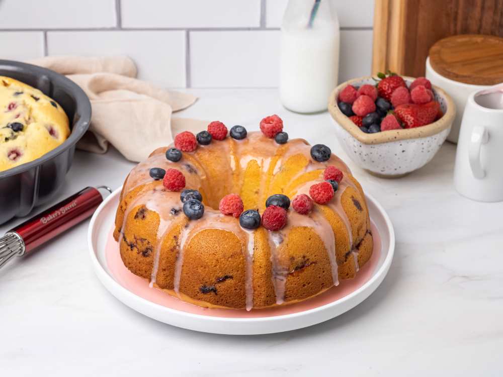 Berry fluted cake topped with fresh berries and glaze