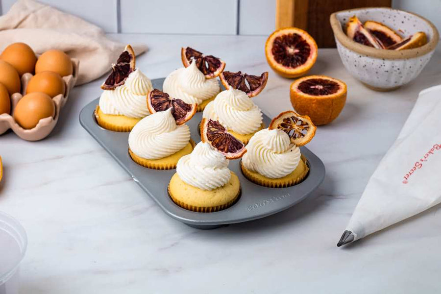 Blood orange cupcakes topped with cream and blood orange slices