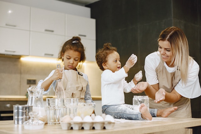Mother and two children baking together in the kitchen