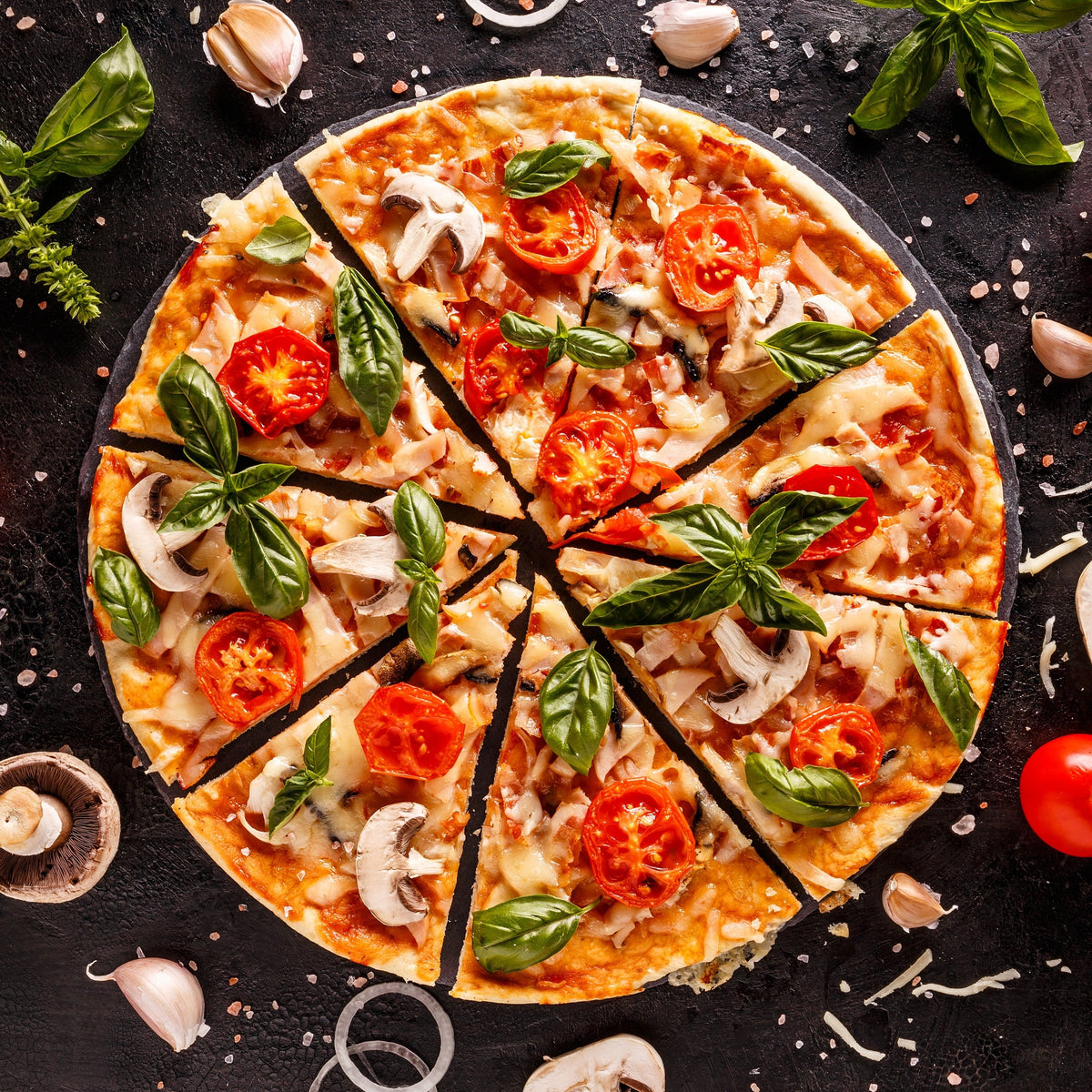 Sliced pizza with tomatoes, mushrooms and herbs on a dark table