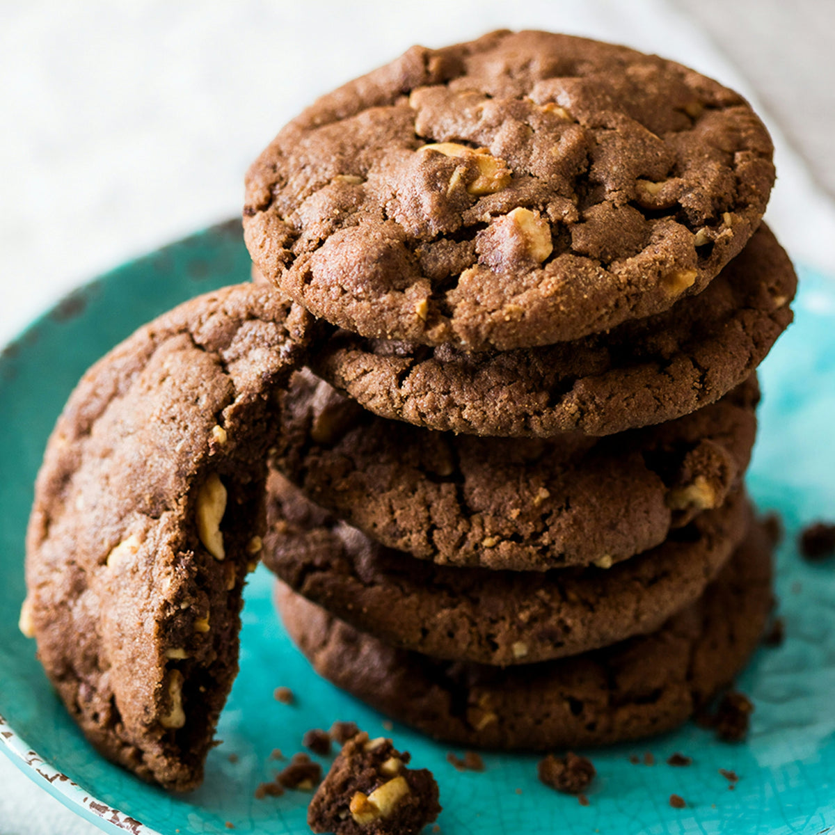 Stack of chocolate chunk cookies on a teal plate