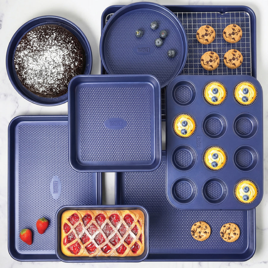 Navy Baker's Secret bakeware set filled with muffins, cupcakes, brownies and a tart