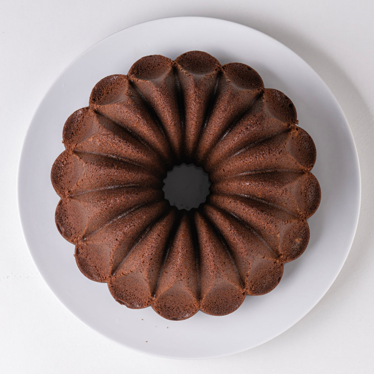 Chocolate Fountain fluted cake on a white plate, top view